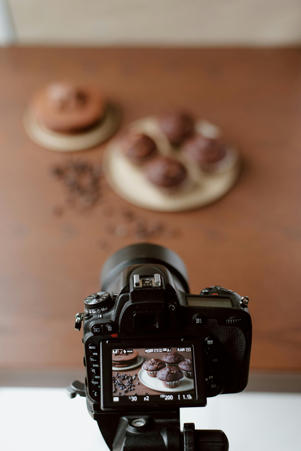 Camera on a tripod framing a plated dessert during a small-business branding shoot