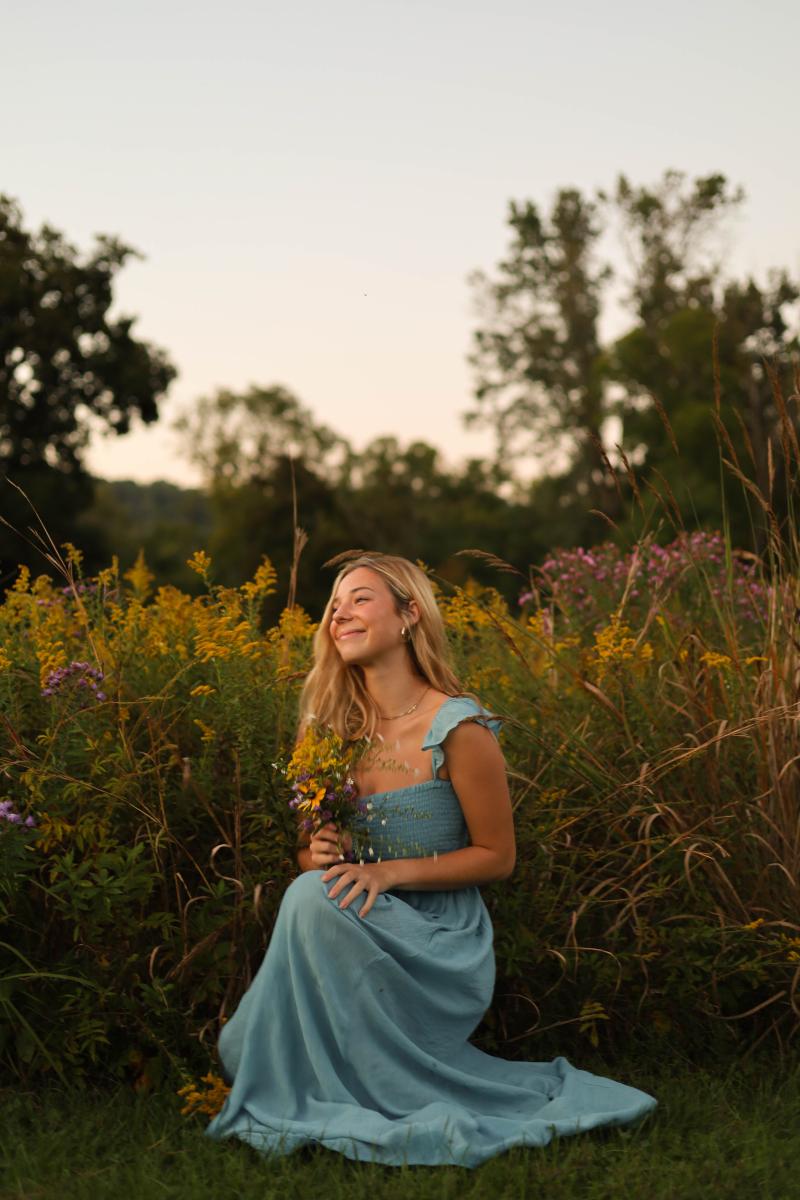 Senior portrait in a field of goldenrod at sunset